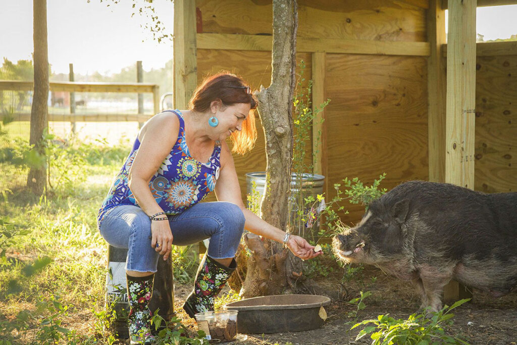 woman with pig in a barn