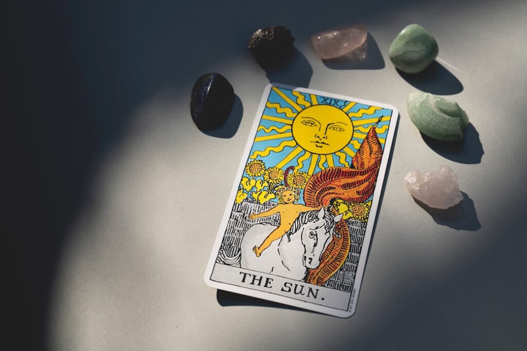tarot card with six healing stones above it