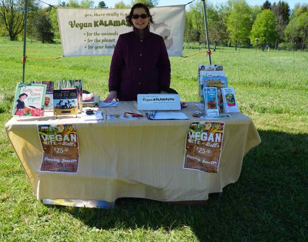 Hillary Rettig with vegan literature at table at vegfest