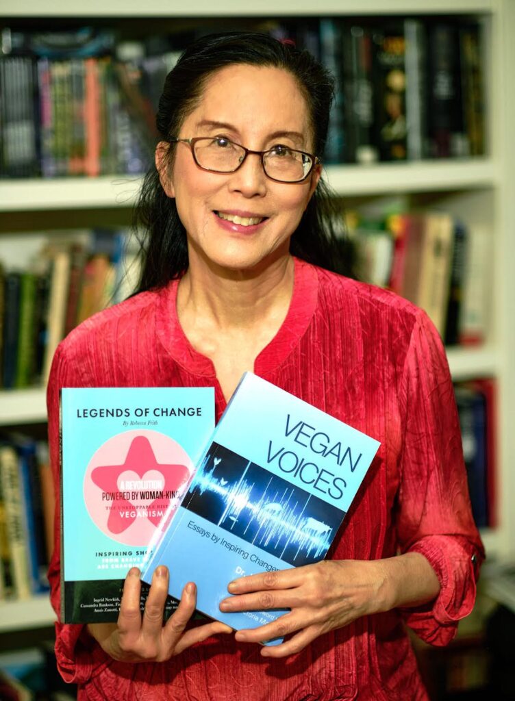 Joanne Kong, vegan Renaissance woman, holding the book she authored "Vegan Voices"