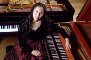 Joanne Kong, vegan Renaissance woman, sitting at piano on stage